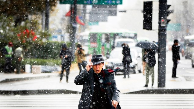 Homem atravessa rua durante tempestade de neve no centro de Seul, na Coreia do Sul