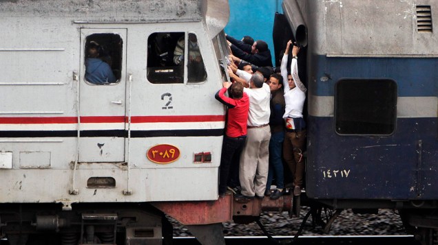 Passageiros viajam em trem superlotado no Cairo, nesta segunda-feira (18)