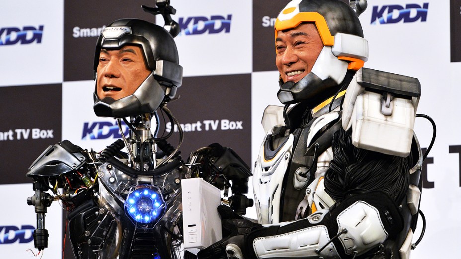 Com uma roupa robótica, o ator japonês Ken Matsudaira posa ao lado de um robô feito à sua semelhança em uma coletiva de imprensa em Tóquio, no Japão