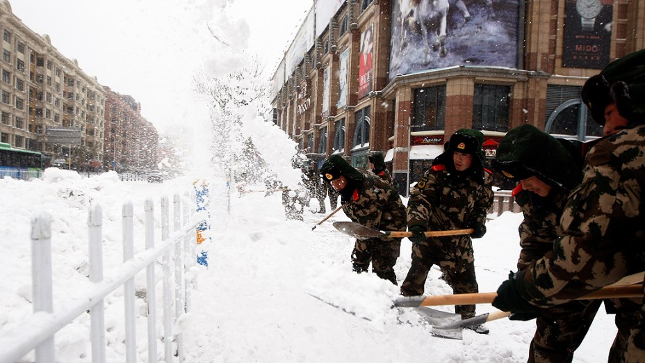 Soldados retiram neve de uma rua na cidade de Harbin, província de Heilongjiang, durante pior tempestade de neve dos últimos 50 anos, na China
