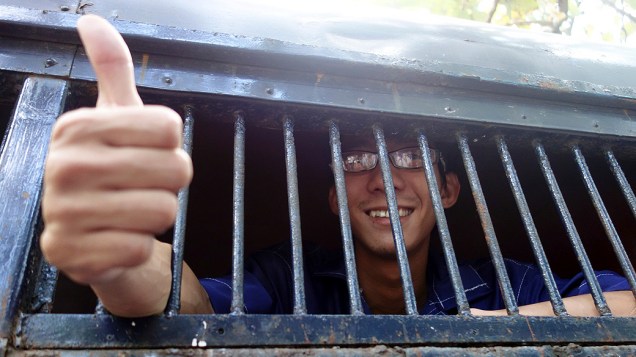 D Nyein Lin, um dos ativistas que protestaram contra um projeto de mina de cobre deixa um tribunal em um caminhão da polícia, nesta sexta-feira (22), em Yangon, em Mianmar
