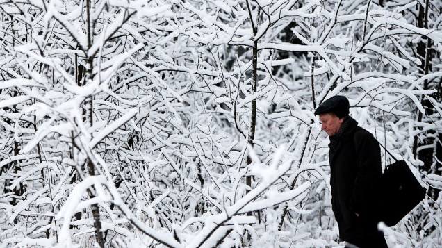Homem caminha por árvores cobertas de neve em uma estação de trem nos arredores de Moscou, Rússia