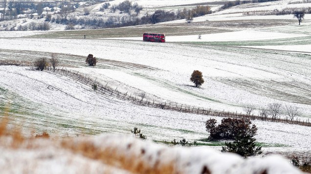 Ônibus transita em um campo coberto de neve nos arredores da cidade de Skopje, na Macedônia