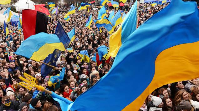 Manifestantes pró União Europeia acenam bandeiras ucranianas durante um comício na cidade de Lviv