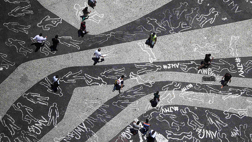 Contornos de giz representando corpos de pessoas mortas foram desenhados durante um protesto na praça da Carioca no centro do Rio de Janeiro representando as 4000 vítimas de violência que morreram no estado, em 2012