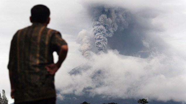 Homem observa a fumaça expelida pelo Monte Sinabung durante uma erupção em Gundaling, Norte de Sumatra, na Indonésia