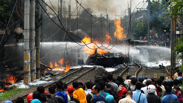 Bombeiros tentam apagar fogo após colisão de trem com um caminhão-tanque, em Jacarta, na Indonésia