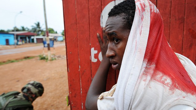 Homem ferido espera por ajuda durante uma operação de desarmamento realizada por soldados franceses em Bangui, na República Centro Africana