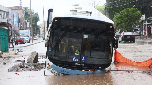 Ônibus cai em buraco na manhã desta quarta-feira (11), durante alagamento na Avenida Vicente de Carvalho na Penha, na zona norte do Rio de Janeiro