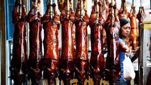 Mulher vende porcos assados para ceia de Natal e Ano Novo em Manila, nas Filipinas