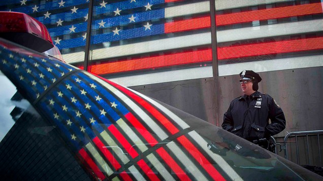 A bandeira dos Estados Unidos refletida na janela de um carro da polícia na Times Square, antes das celebrações de Ano Novo, em Nova York