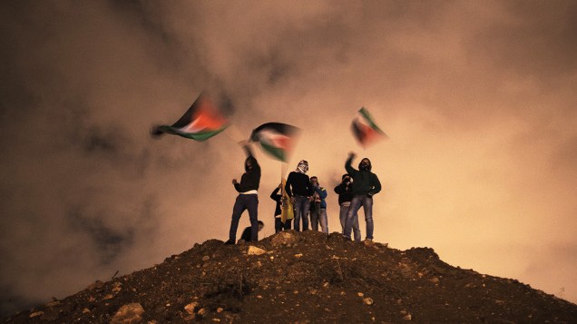 Manifestantes ergueram bandeiras enquanto aguardavam a libertação de prisioneiros em Jerusalém. Israel libertou 26 prisioneiros palestinos em negociações de paz mediadas pelo secretário de Estado dos Estados Unidos John Kerry, em Israel