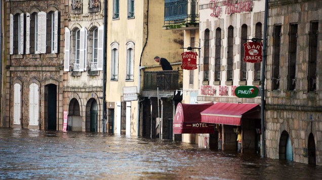 Homem olha para o nível de água no centro da cidade de Quimperle, na França inundada pela cheia do rio Laita