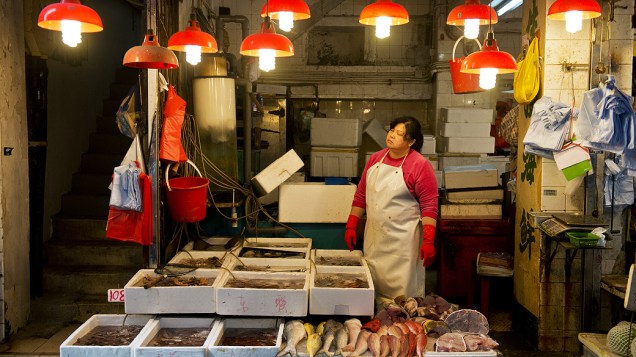 Mulher espera por clientes em sua barraca de frutos do mar em Hong Kong