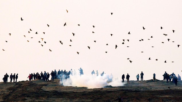 Exército israelense lança bomba de gás lacrimogênio durante confronto com manifestantes palestinos na fronteira israelense com Gaza