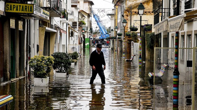 Homem atravessa rua inundada devido as fortes chuvas na cidade de Águeda, em Portugal