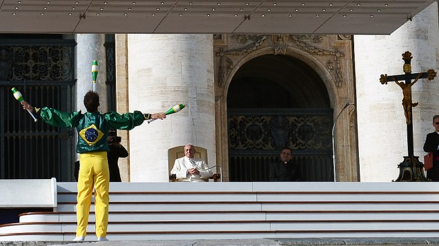 Papa Francisco observa malabarista durante sua audiência na Praça de São Pedro, no Vaticano, nesta quarta-feira (08)