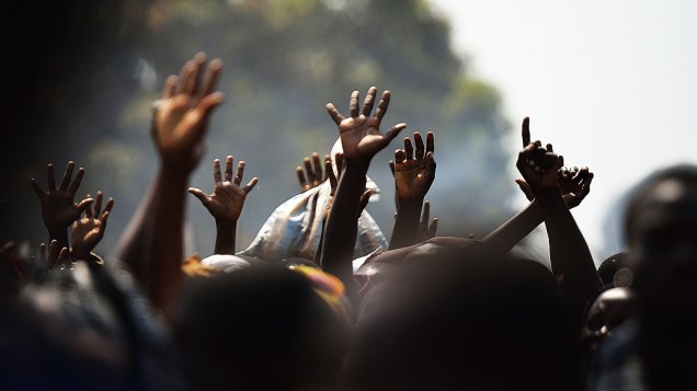 Pessoas levantam as mãos esperando distribuição de comida, na cidade de Bangui, República Centro Africana