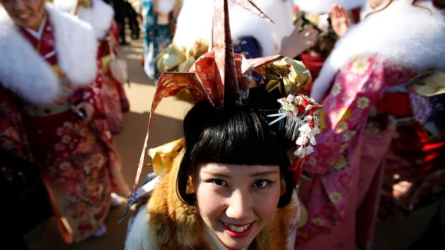 Jovem japonesa é fotografada em parque de diversões em Tóquio, onde comemora o Dia da Idade Adulta nesta segunda-feira (13)
