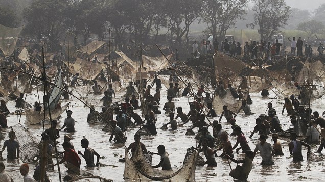 Aldeões saem para pescar durante as comemorações do Bhogali Bihu no lago Goroimari na Índia. O "Bhogali Bihu" marca o fim da época de colheita no estado indiano de Assam