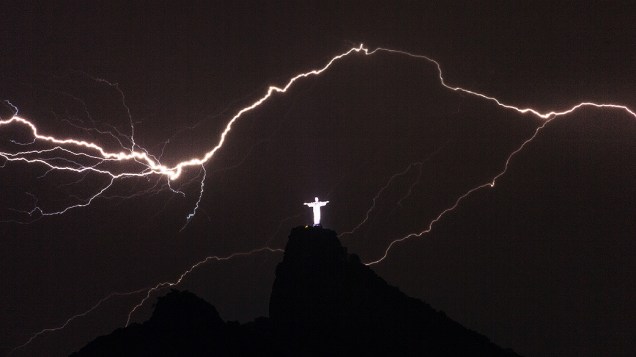 Relâmpagos vistos sobre o Cristo Redentor no alto do Corcovado, no Rio de Janeiro, na madrugada desta terça-feira (14)