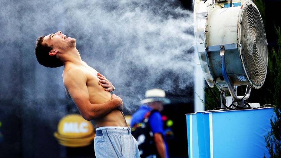 O tenista polonês Jerzy Janowicz se refresca com água durante partida no Aberto da Austrália, em Melbourne. O país vive uma intensa onda de calor nos últimos dias