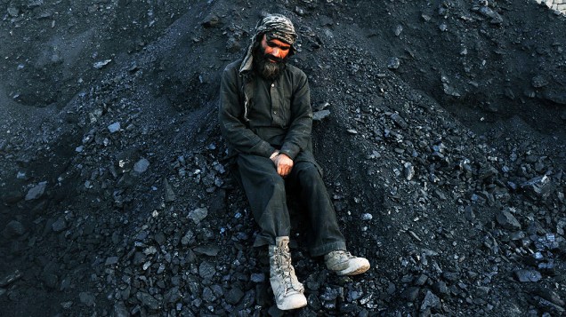 Um vendedor de carvão afegão espera por clientes, nos arredores de Jalalabad, nesta terça-feira (28)