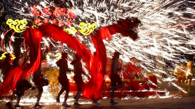 Dançarinos usam fogos de artifício durante uma performance para celebrar o tradicional Festival da Primavera, no primeiro dia do Ano Novo Lunar chinês, que saúda o Ano do Cavalo, no parque de diversões Happy Valley em Pequim
