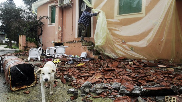 Homem cobre sua casa com lonas de plástico, após terremoto que sacudiu a ilha de Cefalônia em uma semana e centenas de tremores secundários que se seguiram mais tarde na cidade Aghios Demetrios, na Grécia