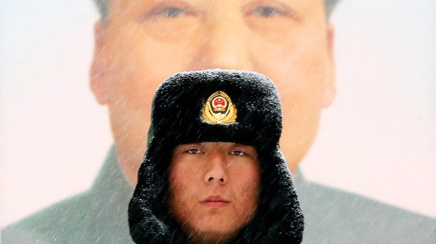 Policial fica de guarda, em meio à neve, em frente do retrato de Mao Tsé-tung, na entrada principal da Cidade Proibida, em Pequim 