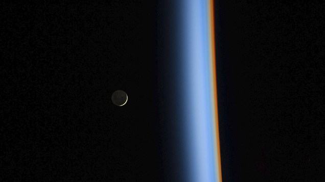 Lua crescente em ascensão à beira da atmosfera terrestre em fotografia divulgada pela Nasa