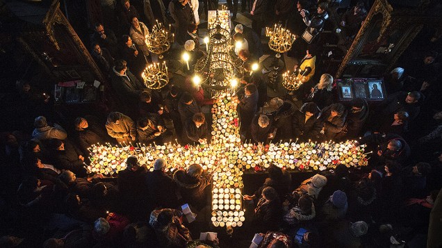 Cristãos ortodoxos se reúnem em torno de velas em forma de cruz durante uma missa celebrada na igreja da Santíssima Virgem, na cidade de Blagoevgrad, Bulgária