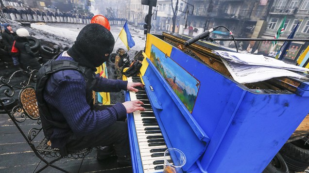 Homem toca piano em uma das barricadas erguidas pelos manifestantes durante os protestos em Kiev, na Ucrânia