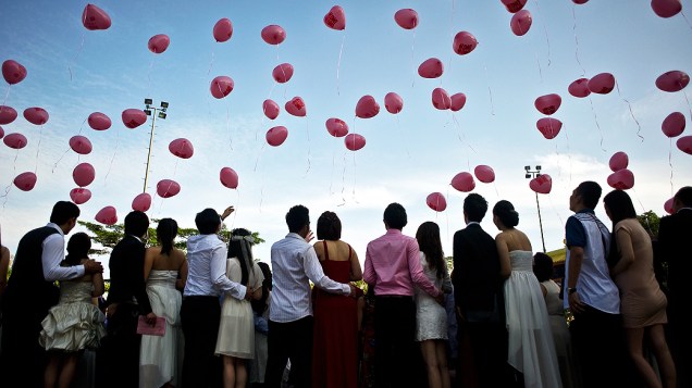 Casais soltam balões durante cerimônia de casamento coletivo realizada em templo em Kuala Lumpur, na Malásia. Cerca de 138 casais escolheram celebrar sua união nesta sexta-feira (14) por ser o dia de São Valentim, considerado o dia dos namorados em boa parte do mundo