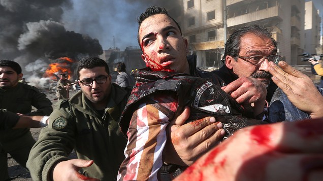 Homem ferido é carregado do local de uma explosão, no subúrbio de Beir Hassan, em Beirute, no Líbano
