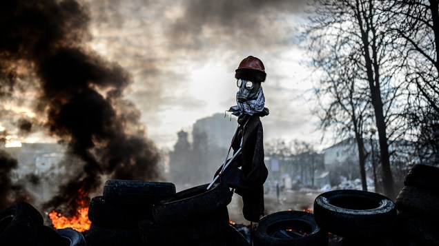 Manifestantes montam espantalho em uma barricada durante protestos contra o governo em Kiev, na Ucrânia