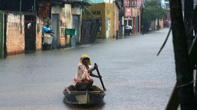 Moradora usa um barco para navegar entre ruas inundadas depois que o rio Acre transbordou devido às fortes chuvas, em Rio Branco, no Acre