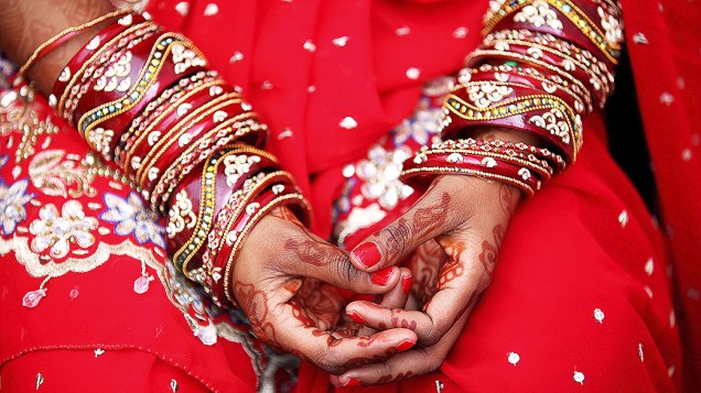 Mulher se prepara para uma cerimônia de casamento coletivo em Nova Délhi, na Índia 