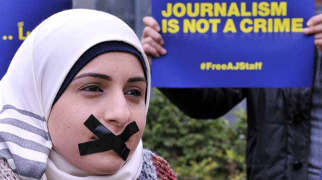 Ativista protesta contra a prisão de vinte jornalistas da Al Jazeera no Egito durante manifestação em favor da liberdade de imprensa em Beirute, no Líbano