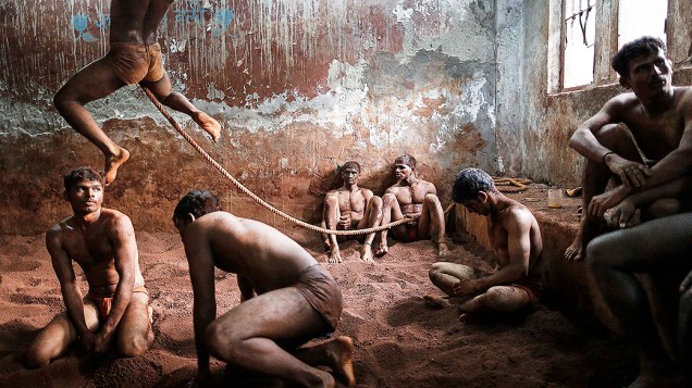 Lutadores de Kushti, atividade praticada na lama, em um centro de treinamento de Mumbai, na Índia