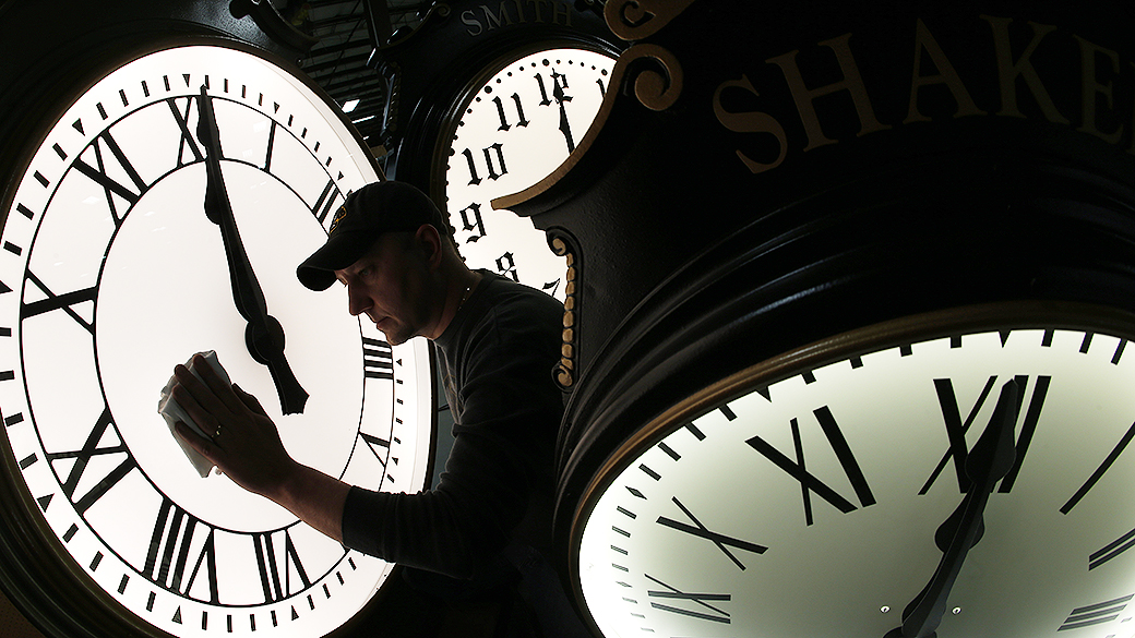Funcionário da Electric Time Company, limpa os relógios da empresa em Medfield, Massachusetts. O horário de verão começa oficialmente no domingo, nos Estados Unidos