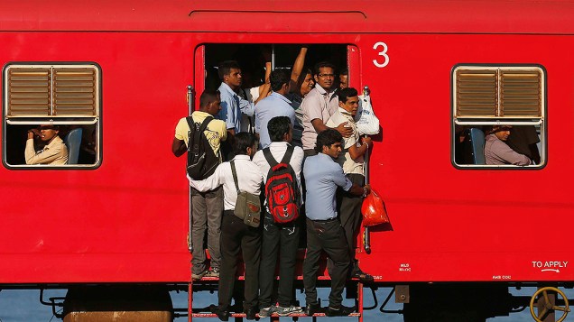 Passageiros se penduram em um trem lotado em Colombo, no Sri Lanka