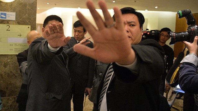 Seguranças chineses à paisana, tentam conter homem que distrubuía folhetos para jornalistas, com teorias sobre o desaparecimento do avião que fazia o voo MH370 da Malaysia Airlines, em um hotel de Pequim