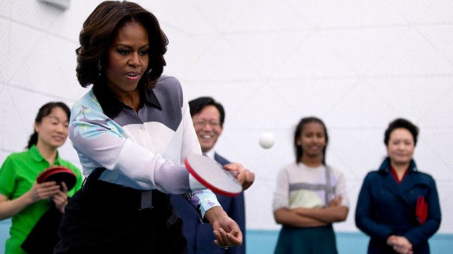 Michelle Obama joga tênis de mesa, durante visita a uma escola que prepara os alunos para universidades no exterior, em Pequim, na China