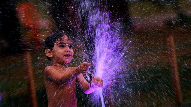Criança brinca com água no parque Colombo, Sri Lanka