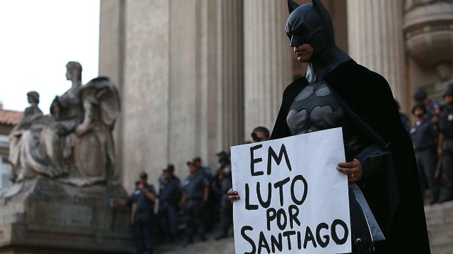 Manifestante vestido como Batman segura cartaz com o nome do cinegrafista Santiago Andrade, que estava internado após ser atingido na cabeça por um rojão em protesto da semana passada e teve morte cerebral anunciada hoje