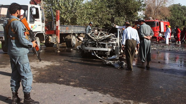 Policiais inspecionam os destroços de um veículo onde uma bomba explodiu deixando 4 mortos, nesta quinta-feira (25), na província de Kunduz, Afeganistão