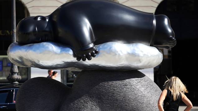 Mulher contempla escultura do artista chinês Li Chen na praça Vêndome, em Paris