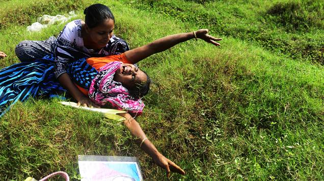 Mãe se desespera ao ver túmulo de filha, uma das vítimas do desabamento de uma fábrica de tecidos na Índia