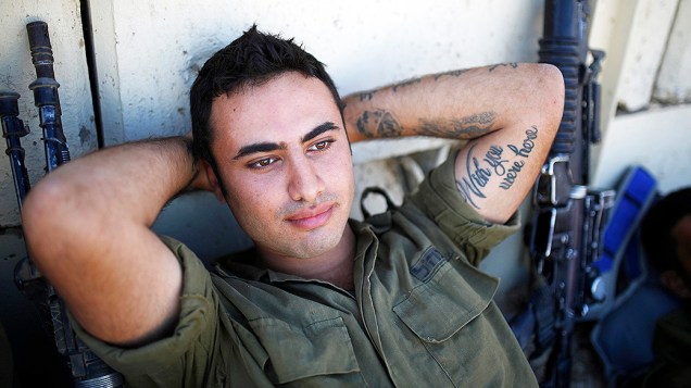 Um soldado israelense descansa próximo à fronteira de Gaza nesta quinta-feira (7). Israel e o Hamas entraram em um acordo de cessar-fogo enquanto mediadores egípcios tentam negociar o fim da guerra com representantes dos dois países
